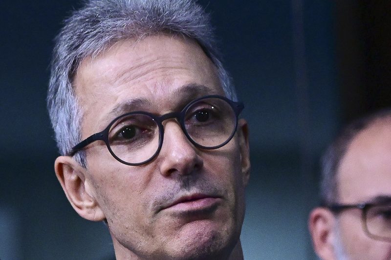 Fotografia. Romeu Zema, de terno escuro, gravata e óculos, fala durante entrevista coletiva no Senado Federal.